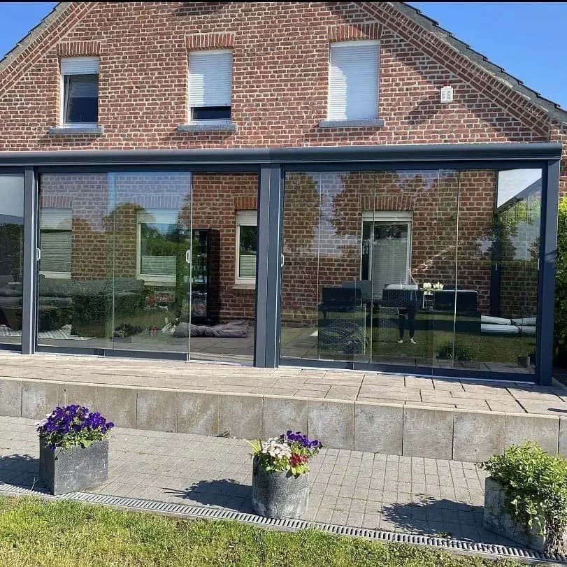 Veranda met een glazen front aan een bakstenen woning